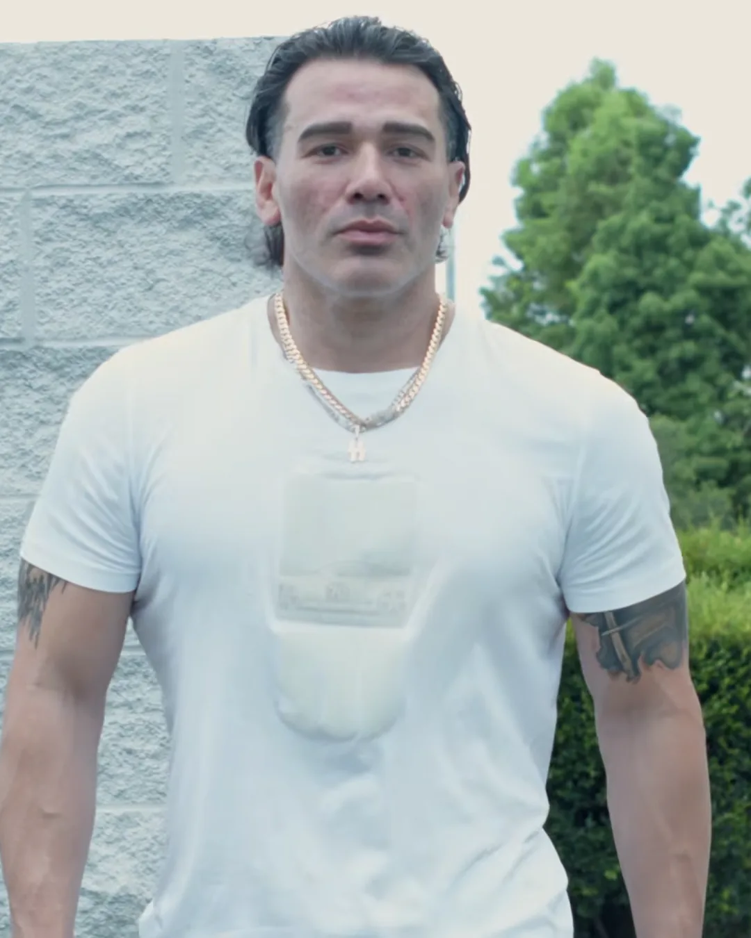 Paul Miller standing full length in a white t-shirt outside