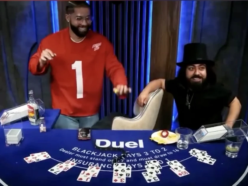 Duelin p&ouml;yd&auml;ss&auml; Dealer Drakeksi nimetty hahmo silinterip&auml;isen is&auml;nn&auml;n vieress&auml;